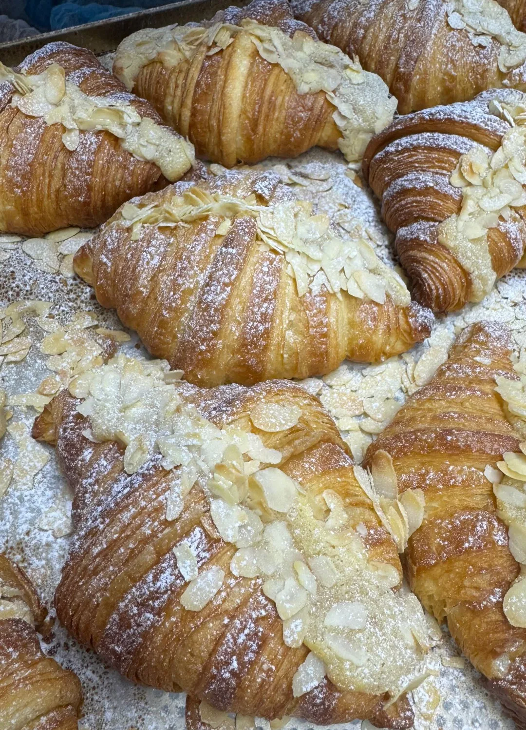 Almond croissants topped with almonds and powdered sugar