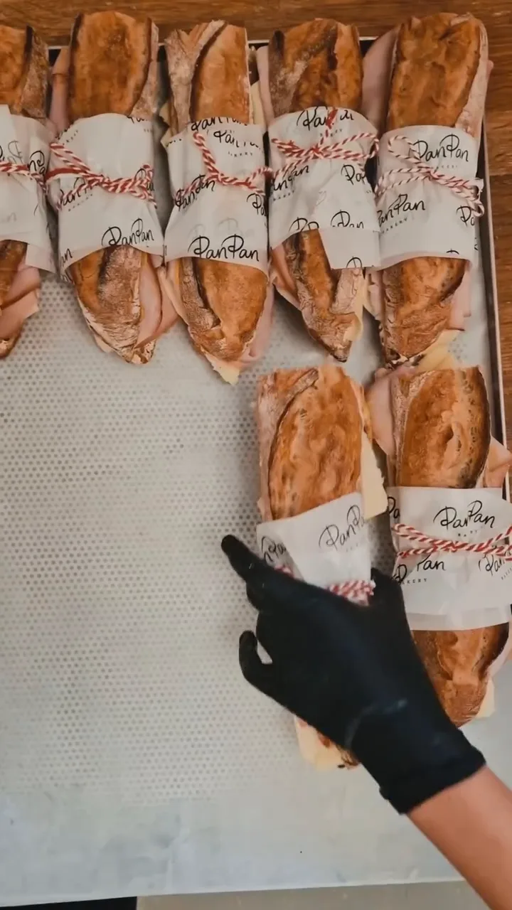 Baguette sandwiches wrapped in paper at the counter